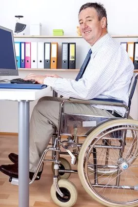 Mann im Rollstuhl am Schreibtisch