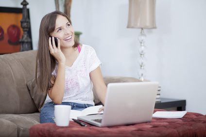 Happy woman working at home and talking to a customer